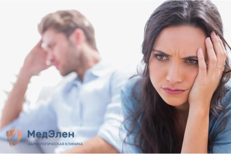 Девушка держится за голову отвернувшись от парня